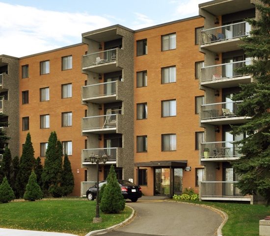 Le Bourg Avant-Garde, immeuble de brique orangée de cinq étages avec balcons