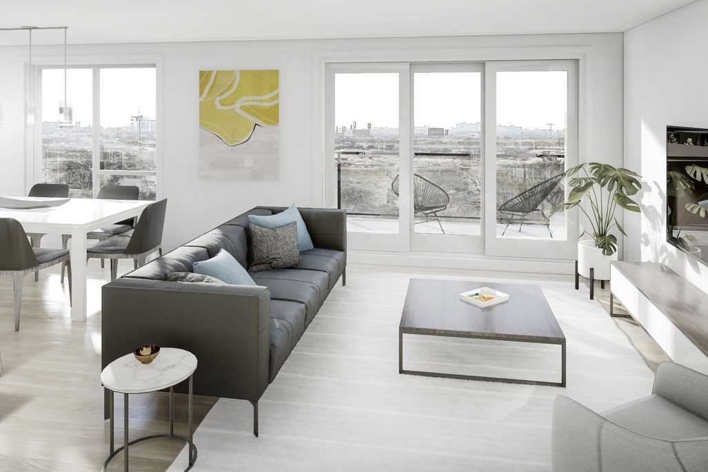 Salon lumineux d'un condo Luxenbourg, canapé gris et table basse devant la fenêtre